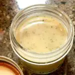 How To Make The Best Homemade Toothpaste closeup of homemade whitening toothpaste in mason jar
