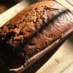 It's Pumpkin Season! The Ultimate Pumpkin Bread Recipe Photo of freshly baked pumpkin bread on cutting board with knife and cream cheese frosting
