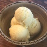 How To Make Homemade Vanilla Bean Ice Cream 3 scoops ice cream in green bowl