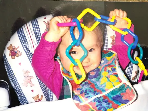 Motherhood What It Means To You child in high chair playing