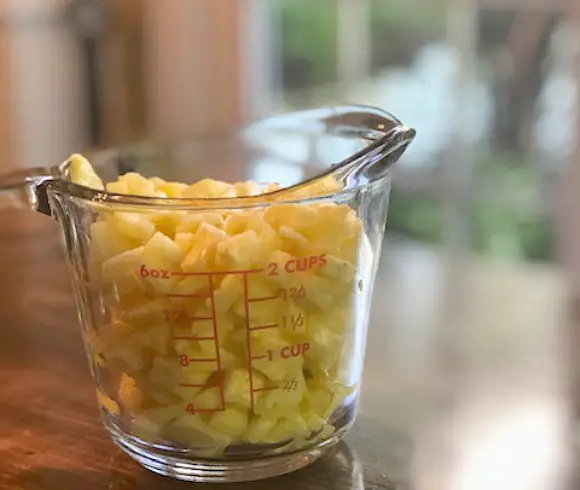 Best Pineapple Salsa Recipe example of diced fresh pineapple in measuring cup