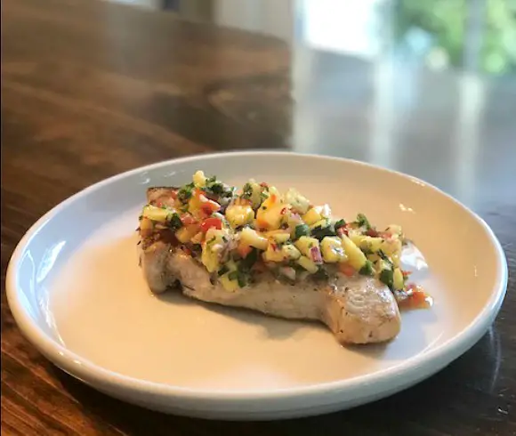 Best Pineapple Salsa Recipe salsa atop grilled swordfish on plate