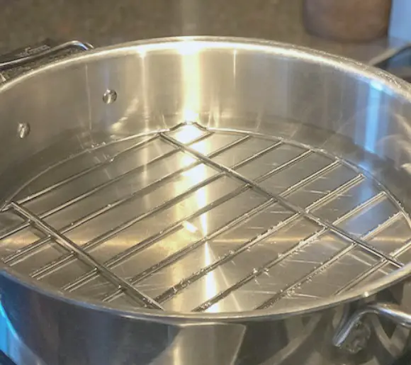 Dandelion Salve And Its Many Uses showing pan used to with rack in bottom of pan to make dandelion salve