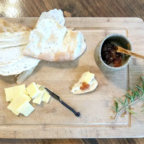 Easy Homemade Flatbread Crackers displayed on cutting board with hot pepper jam and cheese