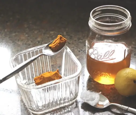 How To Boost Your Immune System Naturally This Winter image of ingredients needed to make a turmeric toddy, turmeric paste, honey, coconut oil displayed on countertop