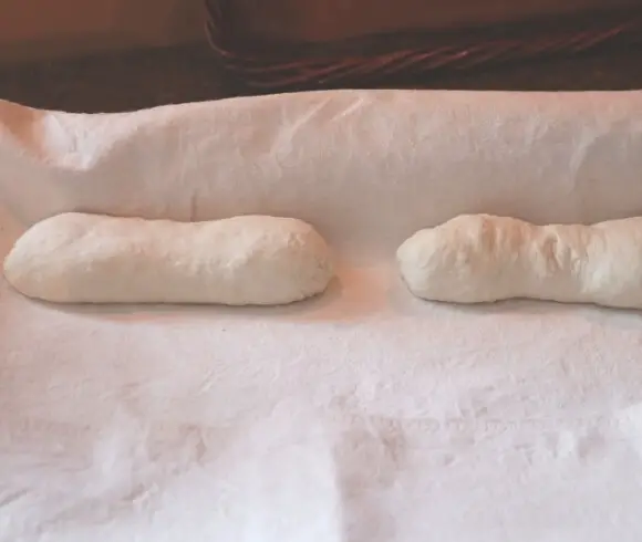 Homemade Baguettes image showing 2 shaped dough rolls on floured pastry cloth