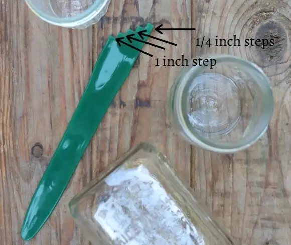 Headspace For Canning image showing headspace measurement tool resting on wooden board with several empty mason jars and black arrows pointing to measurement steps