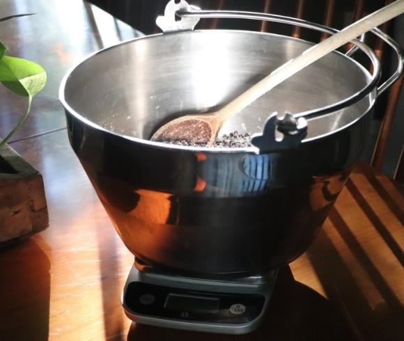 Elderberry Jam Recipe image showing maslin pan with wooden spoon in it resting on top of a kitchen scale on wooden table