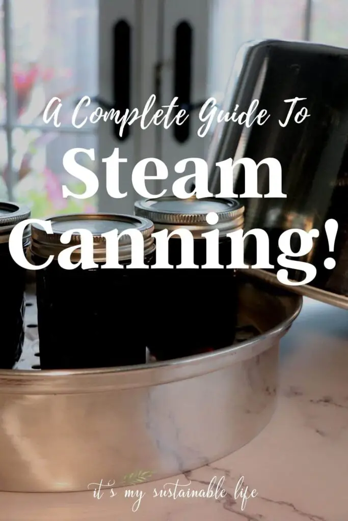 Steam Canning - A Complete Guide pin made for Pinterest showing featured image of steam canner with three jars of jam in the bottom of the pan with steam canner cover resting next to it on a white marble table top