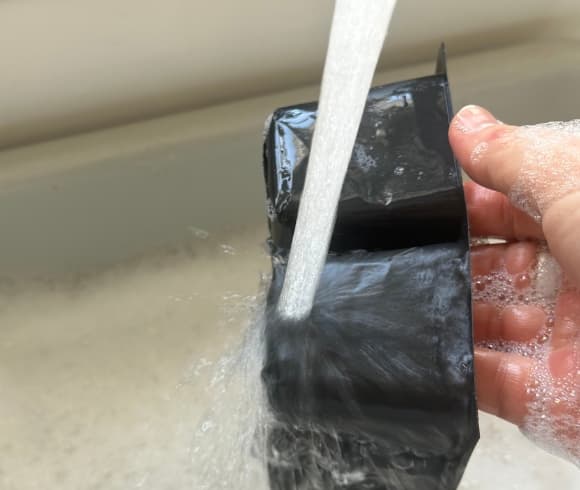 How To Sanitize Seed Trays image showing seed starting trays (cells) being washed and held under running water